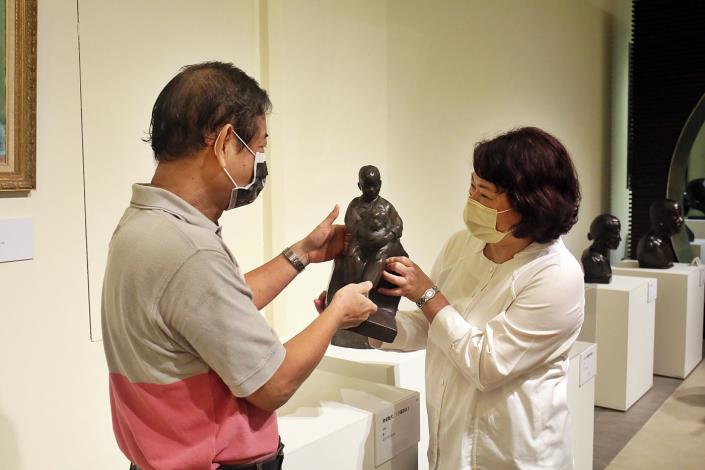 1100903蒲添生110雕塑紀念展A 蒲浩志老師特別拿起爸爸蒲添生大師當年以他為小模特兒的雕像「幼童抱犬」 跟黃敏惠市長分享爸爸的慈愛.JPG